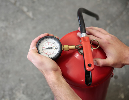 Leistungen im Vorbeugenden Brandschutz aus Köln / NRW Das Bild zeigt eine Feuerlöscher Drucküberprüfung