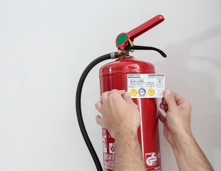 Wartung eines Feuerlöschers in einem Supermarkt in Köln Das Bild zeigt die Prüfung eines Feuerlöschers in einem Supermarkt in Köln